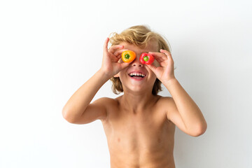 Positive boy covering eyes with bell peppers