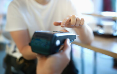 Man holds terminal with a plastic card in his hand. Safe payments concept