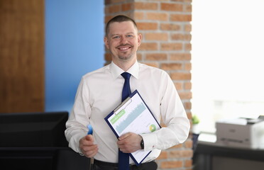 Businessman smiles and holds charts with business figures. Business development consulting concept