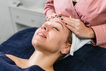 Fototapeta na wymiar Anonymous masseuse doing massage for woman in spa salon