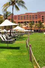 Sun loungers and umbrellas on sea beach on sunny day. One of best resorts in the Gulf of Oman