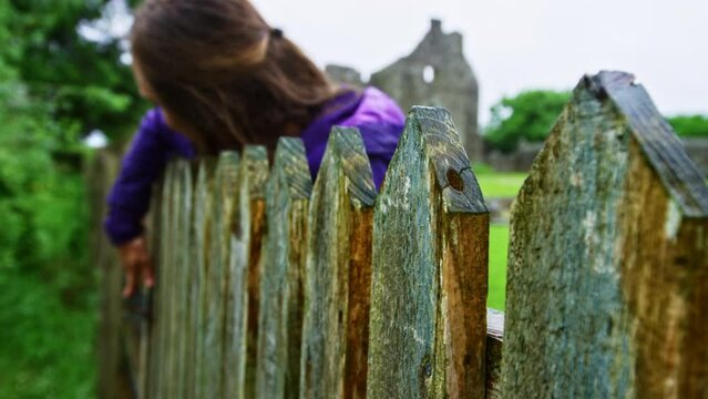 Woman opening gate near Tully Castle in Ireland
