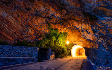 night view of tunnel with footpath and street lights in the rock, beautiful landscape