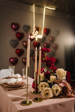 Location Decoration Red Flowers And Decor With Candles For Surprise Marriage Proposal. Luxury Candle Light Dinner Table Setup For Couple On Valentine's Day. Table Setting In Restaurant. Romantic Date.