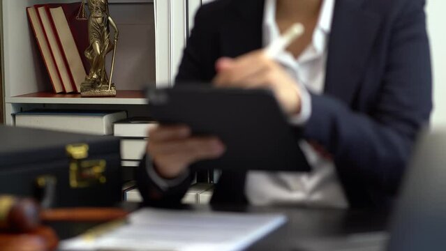Justice and law concept.Male judge in a courtroom the gavel, working with digital tablet computer