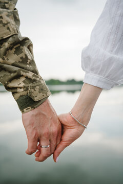 War and love. Closeup man in camouflage uniform holds hand woman. Serviceman saying goodbyes to family. Engagement. Wedding rings. Soldier hugs wife before leaving. Patriotic man go serve country.