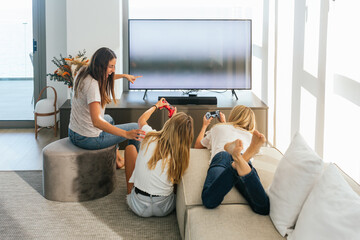 Cheerful women playing videogame on couch