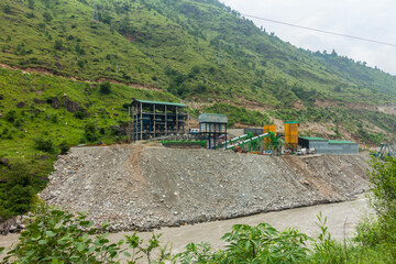 Fototapeta na wymiar Heavy machinery at a Hydro Electric Power Project on River Satluj , Himachal Pradesh, causing river bank erosion in India. River devastation scene.