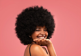 Beauty portrait of flirting young woman with afro hairstyle. Girl winks to the camera and smiles,