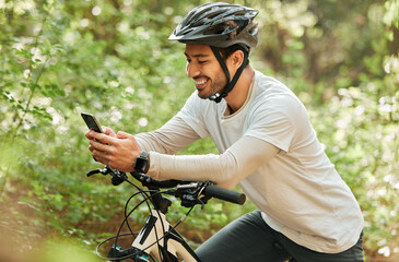 Man, forest and phone on bike, texting and smile for web chat notification on adventure in nature....