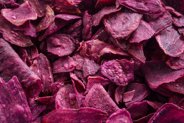 Fried purple sweet potato chips as snacks, close up