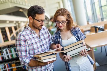 Happy group of success students studying and working together in a college library