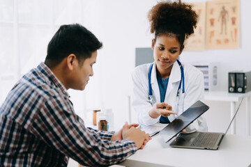 Fototapeta premium The African doctor holds the patient’s. hand Healthcare and medical concept. In hospital..