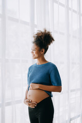 pregnant african american woman at home window white background.
