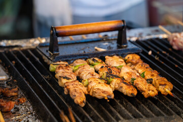 Grilling barbecue meat skewer kebab at traditional night market in South Korea.