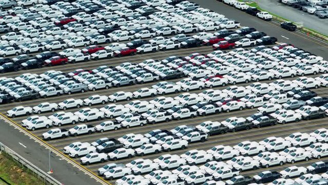 The drone could capture sweeping panoramic shots of the entire parking lot, highlighting the sheer number of cars being produced. Automobile and automotive industry. import and export business
