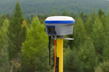 GNSS base station receiver running RTK mode at quiet and tranquil place among forest
