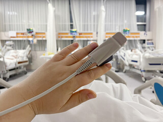 In the Hospital Sick Patient on the Bed. Heart Rate Monitor Equipment is on His Finger, hand closeup