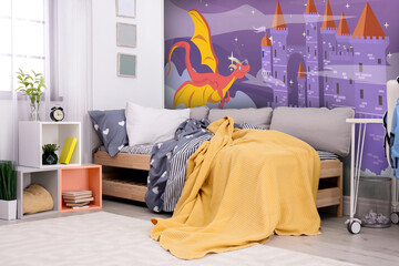 Kid's room interior with comfortable bed. Fairytale themed wallpapers with castle and dragon