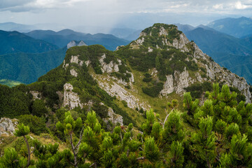 Dramatic landscape with mountains, hills and valleys during the rainy season. High mountain peak covered with rich green juniper vegetation.