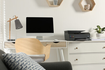 Stylish workplace with modern computer, printer and lamp