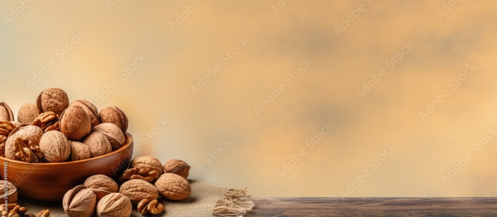 Wall mural Walnuts in plate made of wood isolated pastel background Copy space - Wall murals