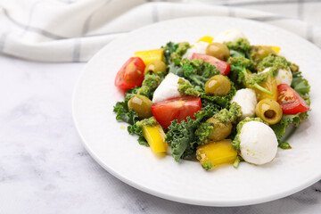 Delicious salad with pesto sauce on white marble table, closeup