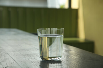 Glass of fresh water on wooden table indoors