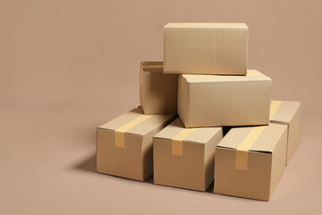 Stack of many cardboard boxes on light brown background, space for text