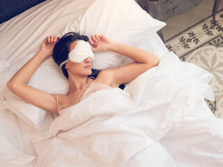 Obraz na płótnie Canvas Calm woman slipping on bed with eye mask