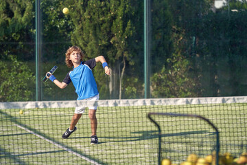 Active boy playing padel on playground