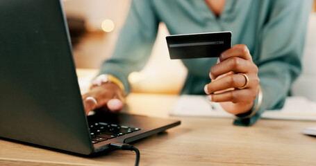 Laptop, credit card and woman hands for business online shopping, transaction or fintech payment in night office. Professional black person typing her banking information on computer or financial app