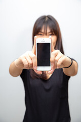 Beautiful asian woman show empty screen of smartphone on white background