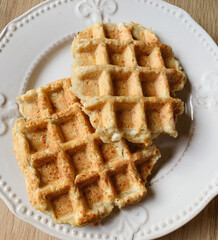 Delicious freshly cooked healthy ricotta waffles on white plate, close up.