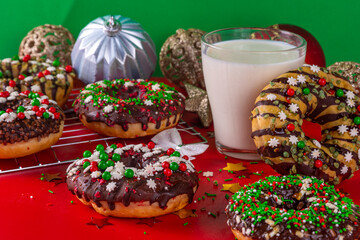 Bright festive decorated Christmas and New Year donuts set, with colorful red, green white snowflake sugar sprinkles. Sweet seasonal Christmas dessert