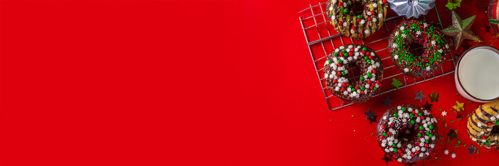 Bright festive decorated Christmas and New Year donuts set, with colorful red, green white snowflake sugar sprinkles. Sweet seasonal Christmas dessert