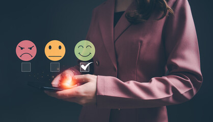 Woman using smartphone choosing green happy smile face icon. feedback rating and positive customer...