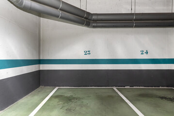 An empty underground car park delimited by white and green paint
