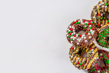 Bright festive decorated Christmas and New Year donuts set, with colorful red, green white snowflake sugar sprinkles. Sweet seasonal Christmas dessert