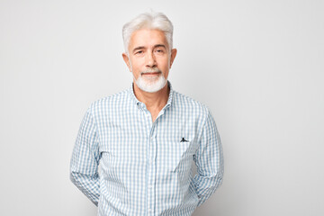 Portrait of confident mature businessman with serious face and gray hair isolated on studio background. Good looking 60 year old man, boss in business casual.
