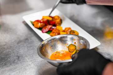 chef cooking chicken sweet and sour sauce on kitchen