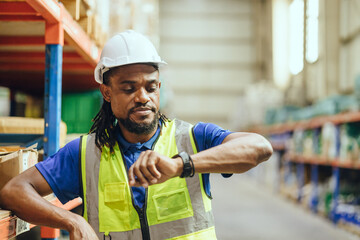 African Black people Engineer male worker looking at wristwatch time check. Industry factory...