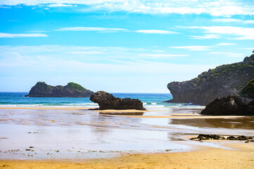 Fototapeta premium View on Playa de Palombina Las Camaras in Celorio, Green coast of Asturias, North Spain with sandy beaches, cliffs, hidden caves, green fields and mountains.