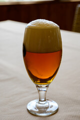 Fresh draught lager or IPA beer is glass served in indoor cafe close up, glass of beer