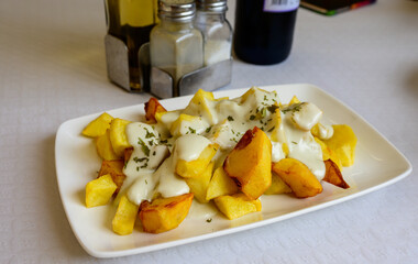 Asturian style roasted potato chips with melted blue cheese cabrales from Las Arenas village,...