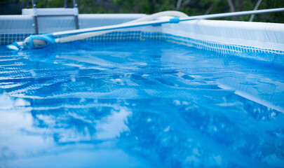 Swimming Pool with vacuum cleaner cleaning Tool. Solar film covers the pool.