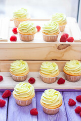 Preparation of pistachio cupcakes with fresh raspberry. Rustic wooden background, close up
