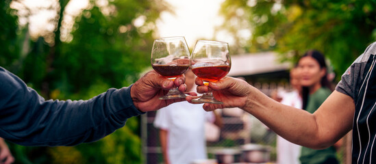 Home Garden BBQ Party, Wine Glasses Clink in Family Toast, enjoying harvest time together outside at front of house, grandfather and grandfather asian people, man and woman