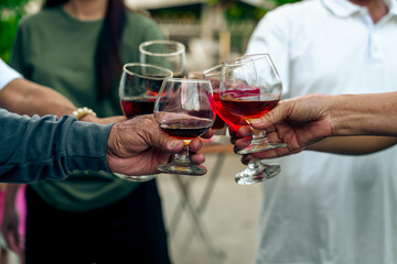 Home Garden BBQ Party, Wine Glasses Clink in Family Toast, enjoying harvest time together outside at front of house, grandfather and grandfather asian people, man and woman