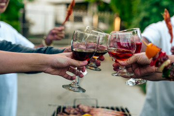 Home Garden BBQ Party, Wine Glasses Clink in Family Toast, enjoying harvest time together outside at front of house, grandfather and grandfather asian people, man and woman